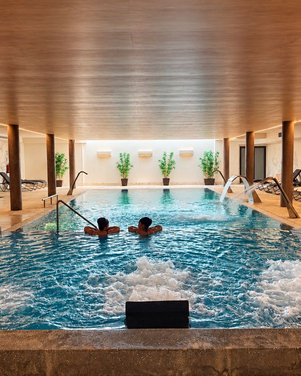 Piscine intérieure du spa du Porta do Sol, plafond en bois et jets d’eau
