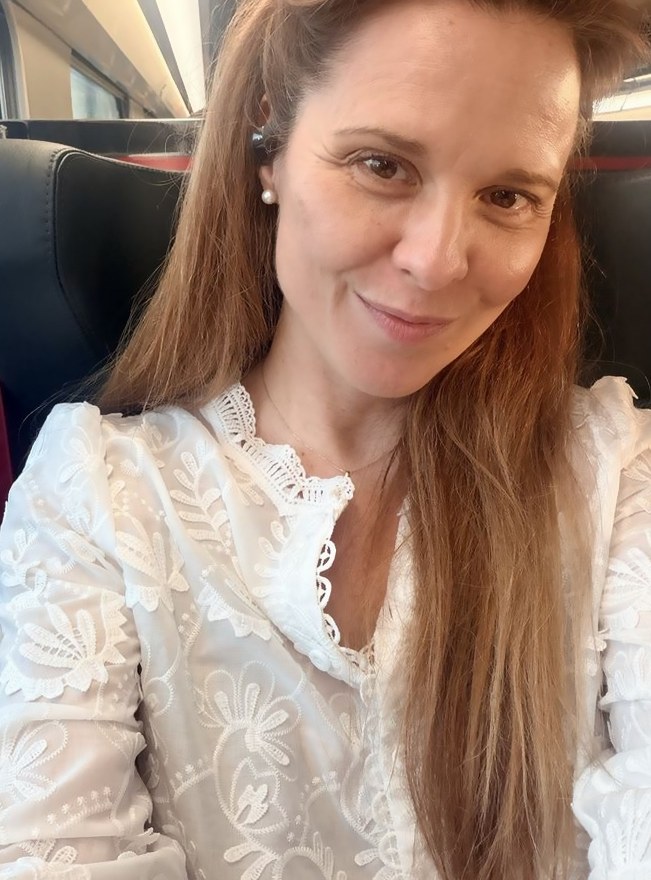 Selfie d’Amélie dans le train, blouse blanche brodée, léger sourire