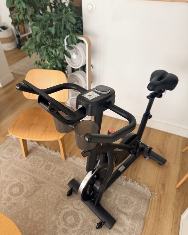 Le vélo Merach vu de trois quarts, avec sa selle, son guidon et ses porte-gobelets
