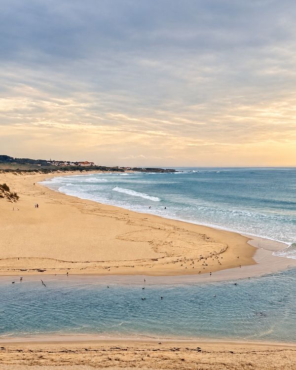 Vue du balcon : l’estuaire, la plage et l’océan sous un ciel du soir