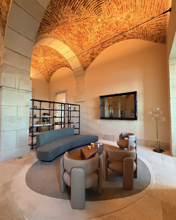 Salon sous des voûtes en brique, canapé bleu et fauteuils